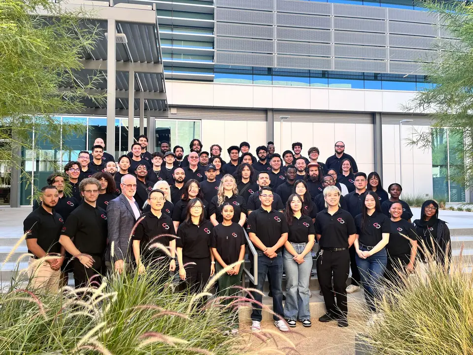 Group photo of the UNLV Cyber Clinic team in matching black shirts outside a campus building.